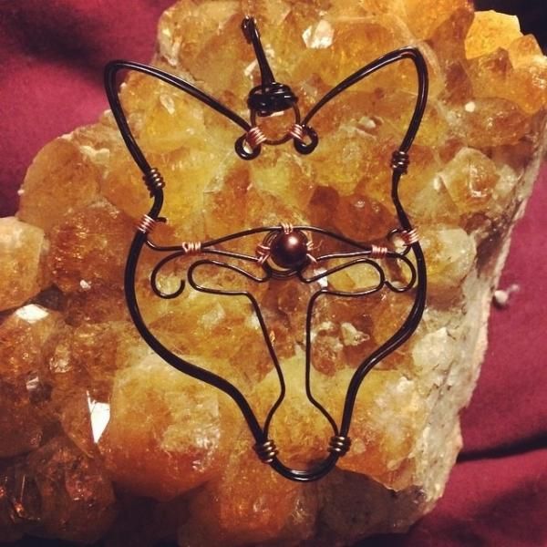Wire cat face sculpture on orange crystal stone