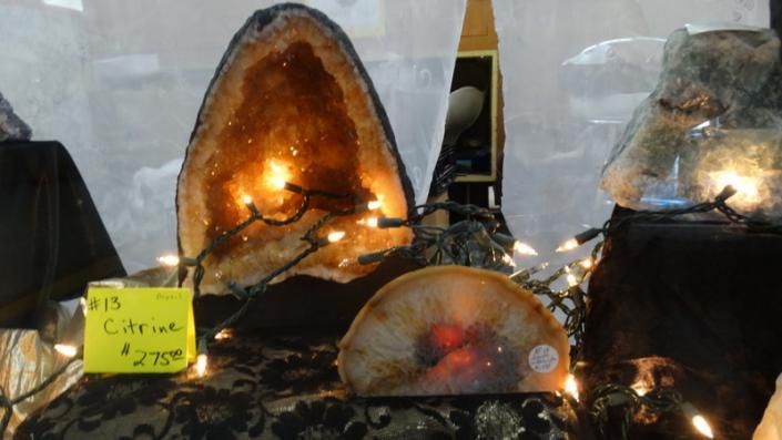 Glowing amber crystal display on a table, with a small price tag and surrounding lights