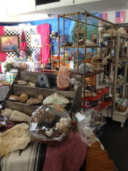 Colorful indoor market stall with crystals, stones, and decorative items on shelves and tables