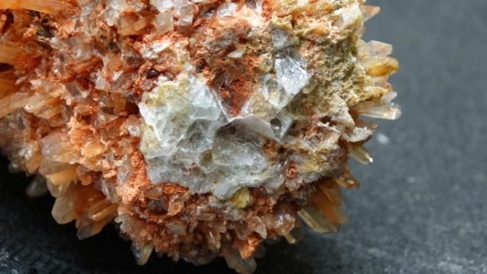 Orange and white crystal cluster on a dark background