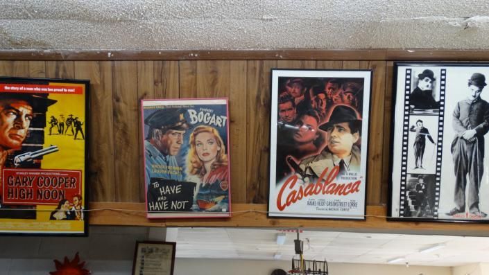 Vintage movie posters displayed in a row on a wooden wall shelf