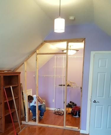 A man is kneeling down in a room with purple walls.