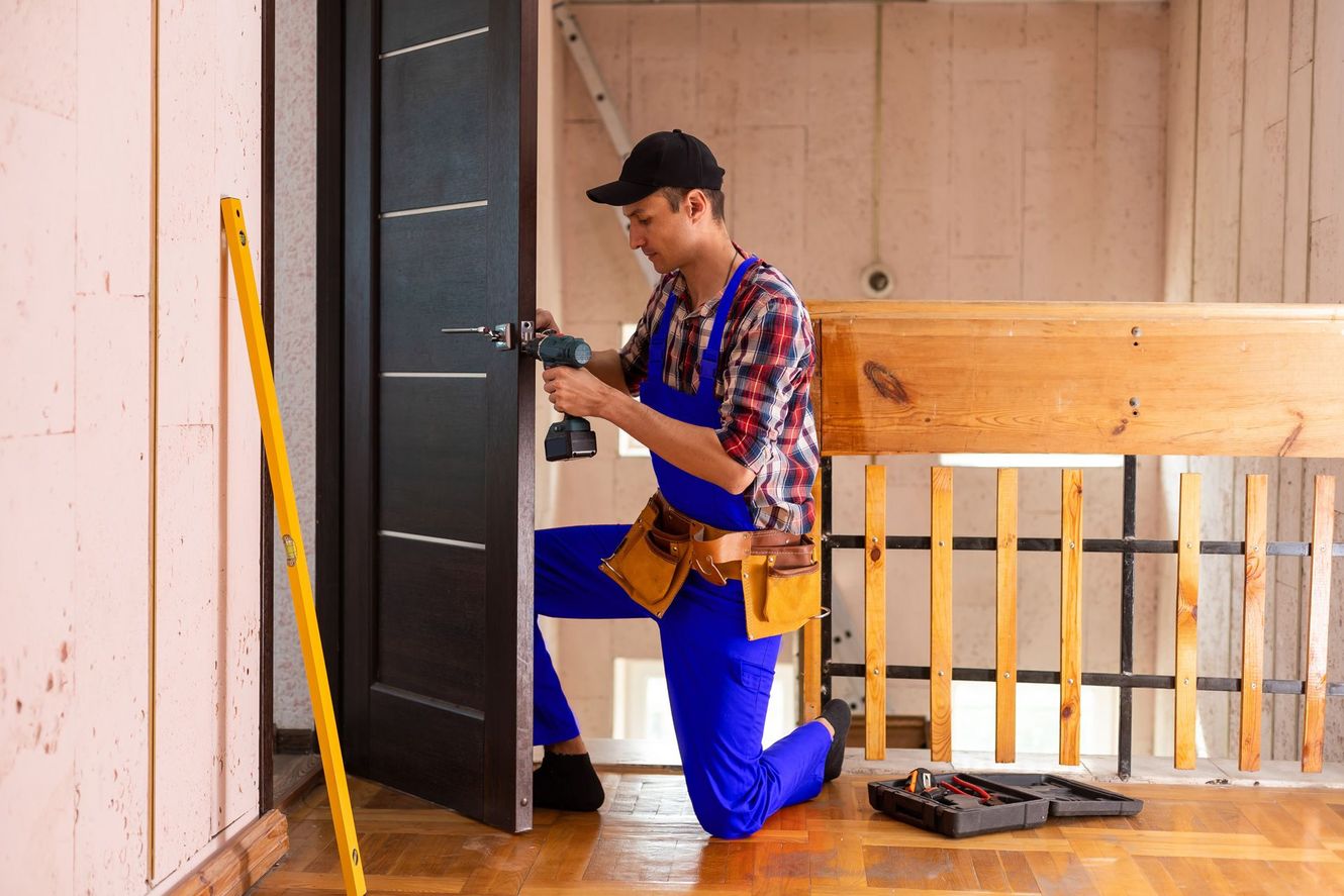 A man is fixing a door with a drill.