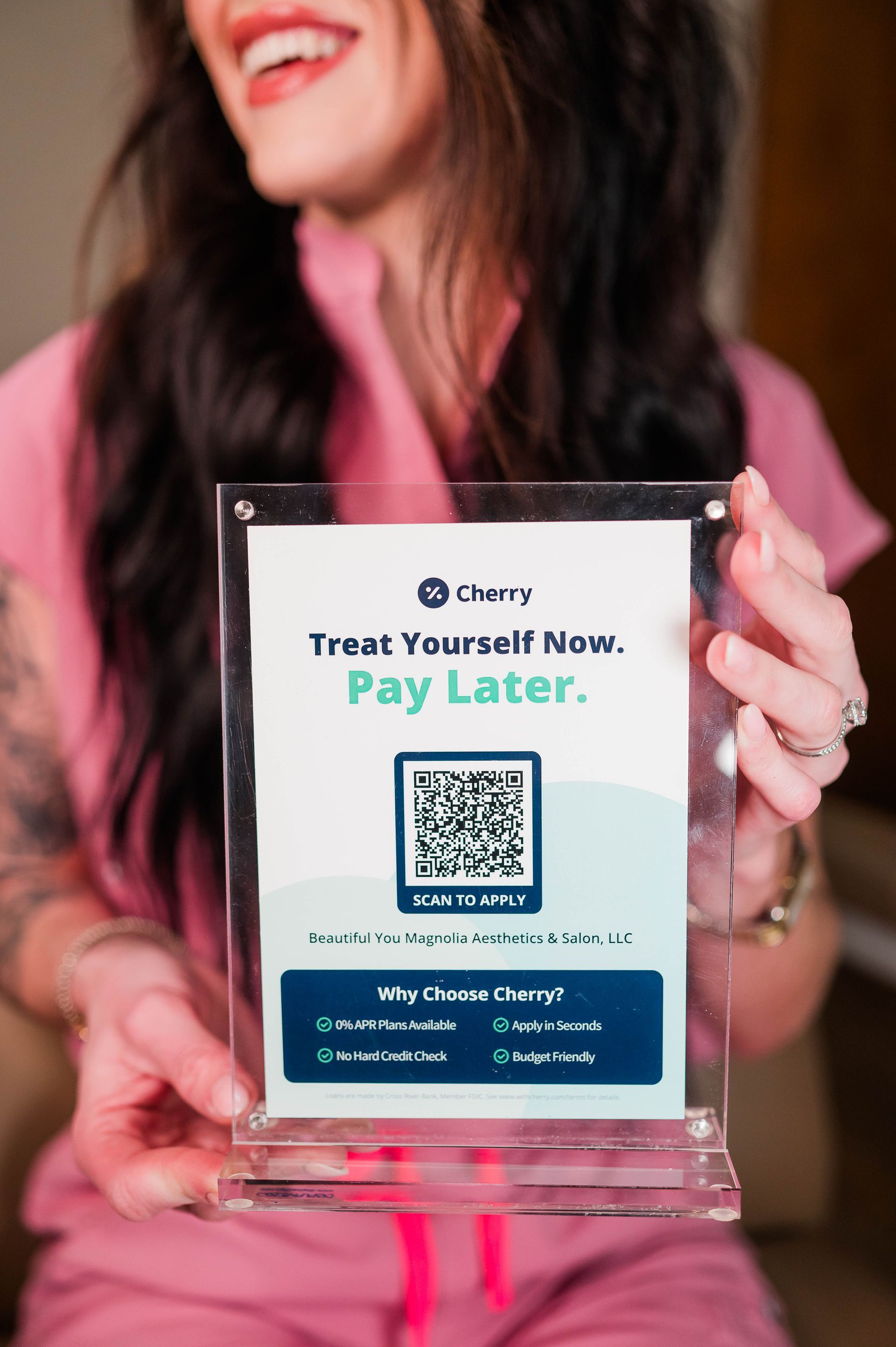 Woman in pink scrubs holding a clear sign with Cherry logo and 