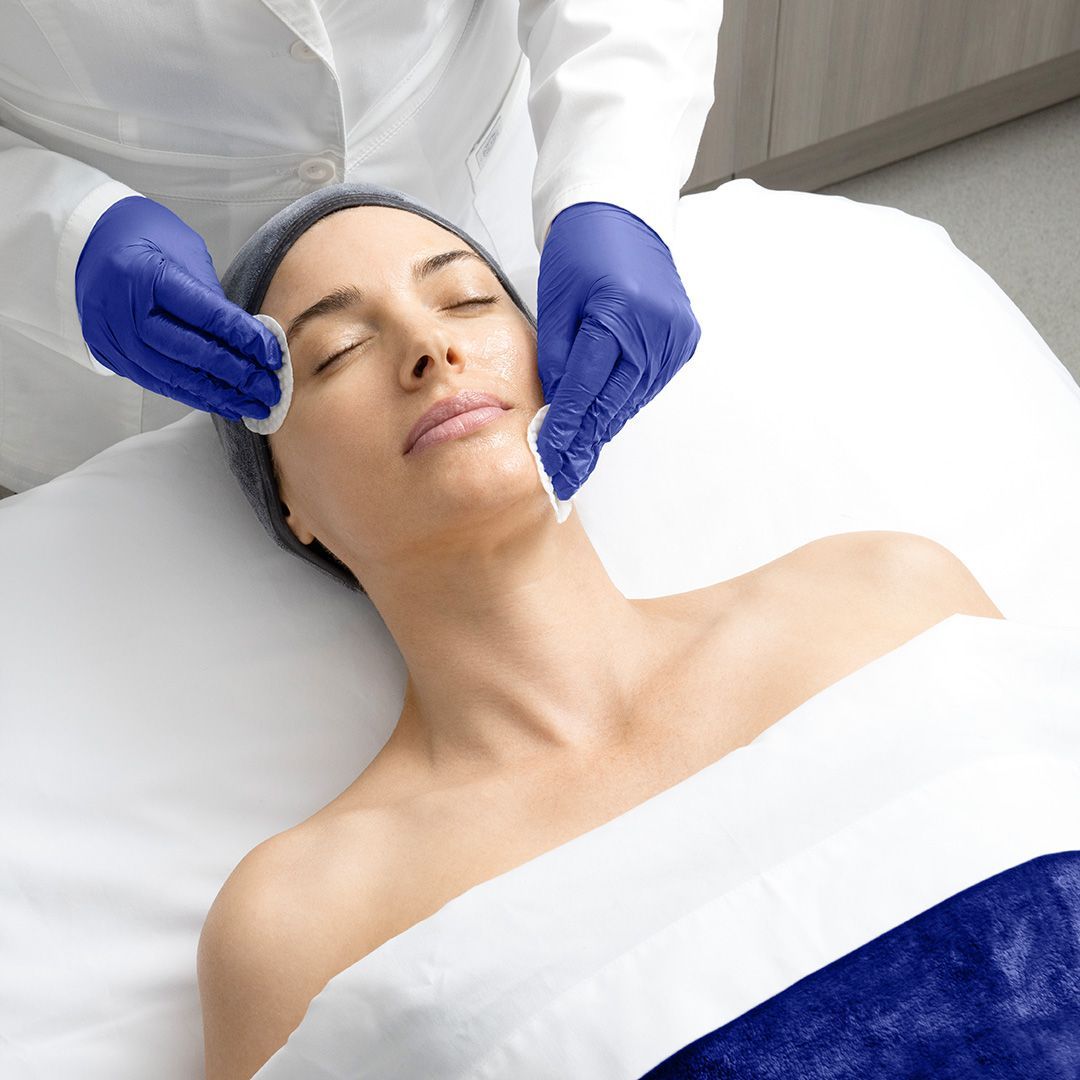 A woman is laying on a bed getting a facial treatment