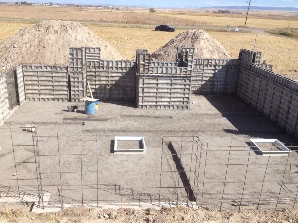 A large concrete wall is being built in a field