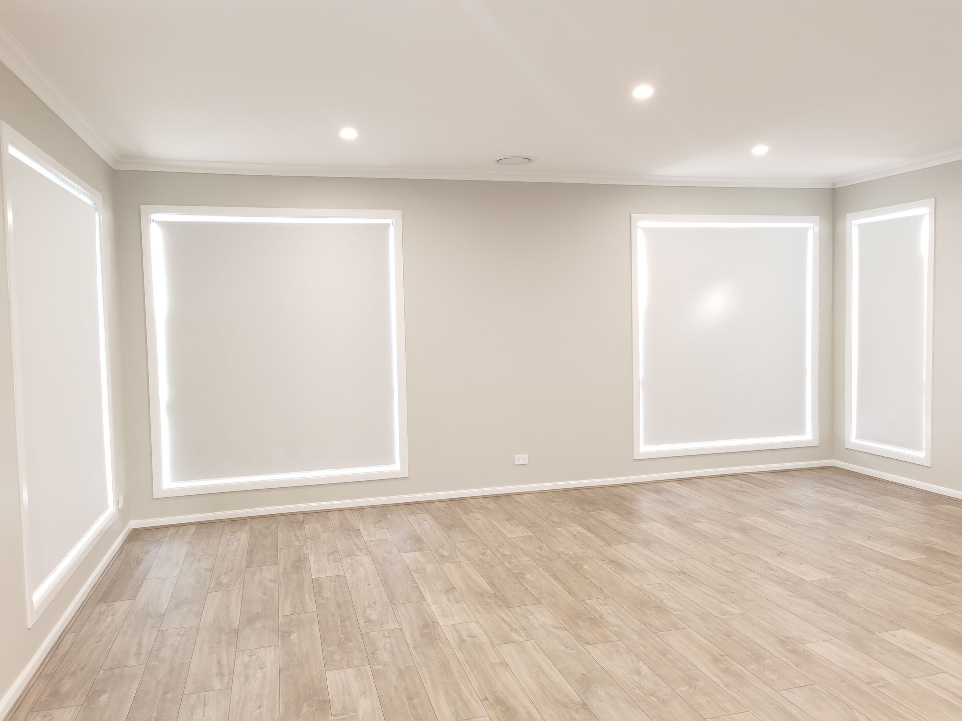 An empty room with a wooden floor and white walls.