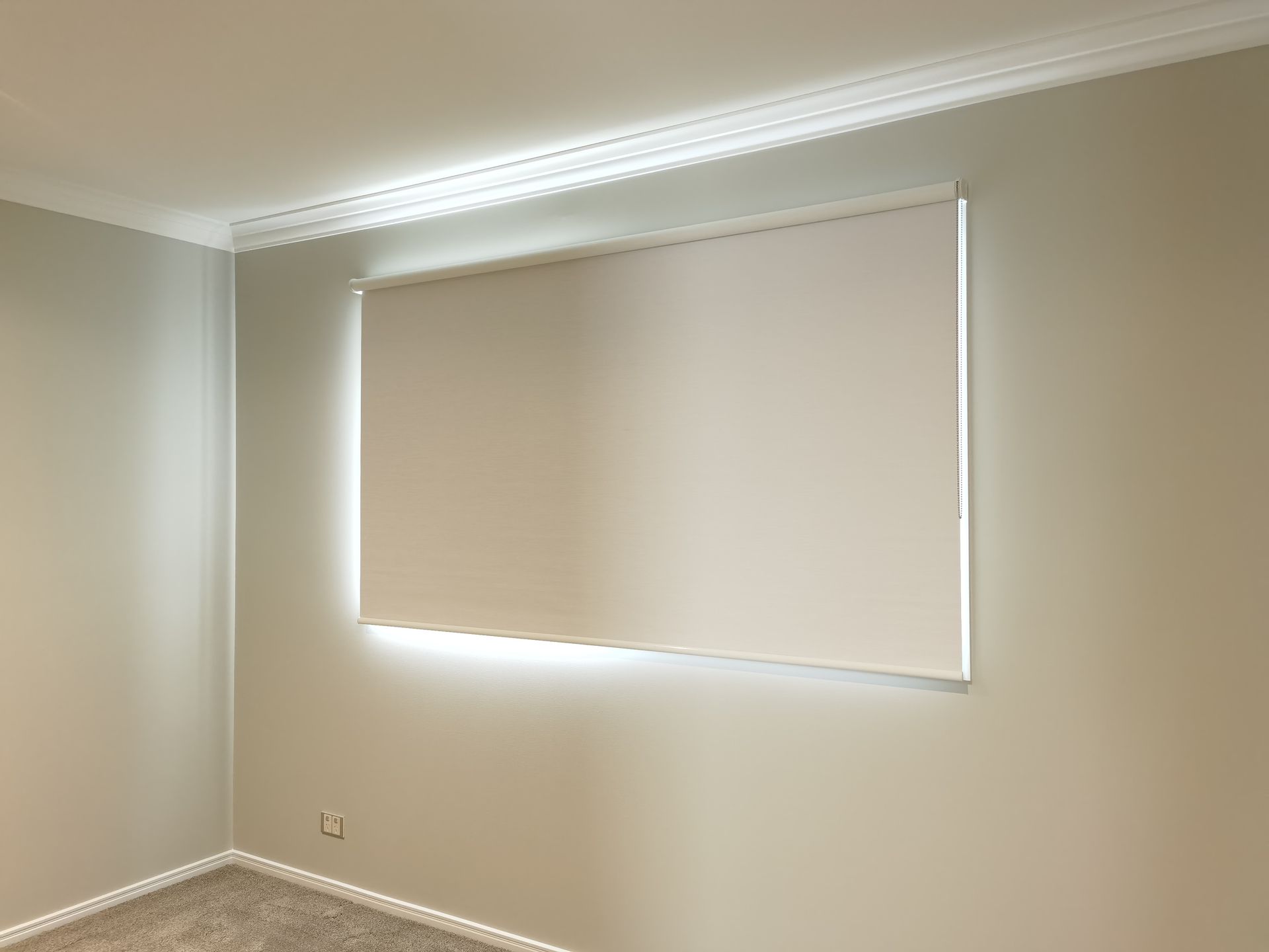 An empty room with a large window and a light on the wall.