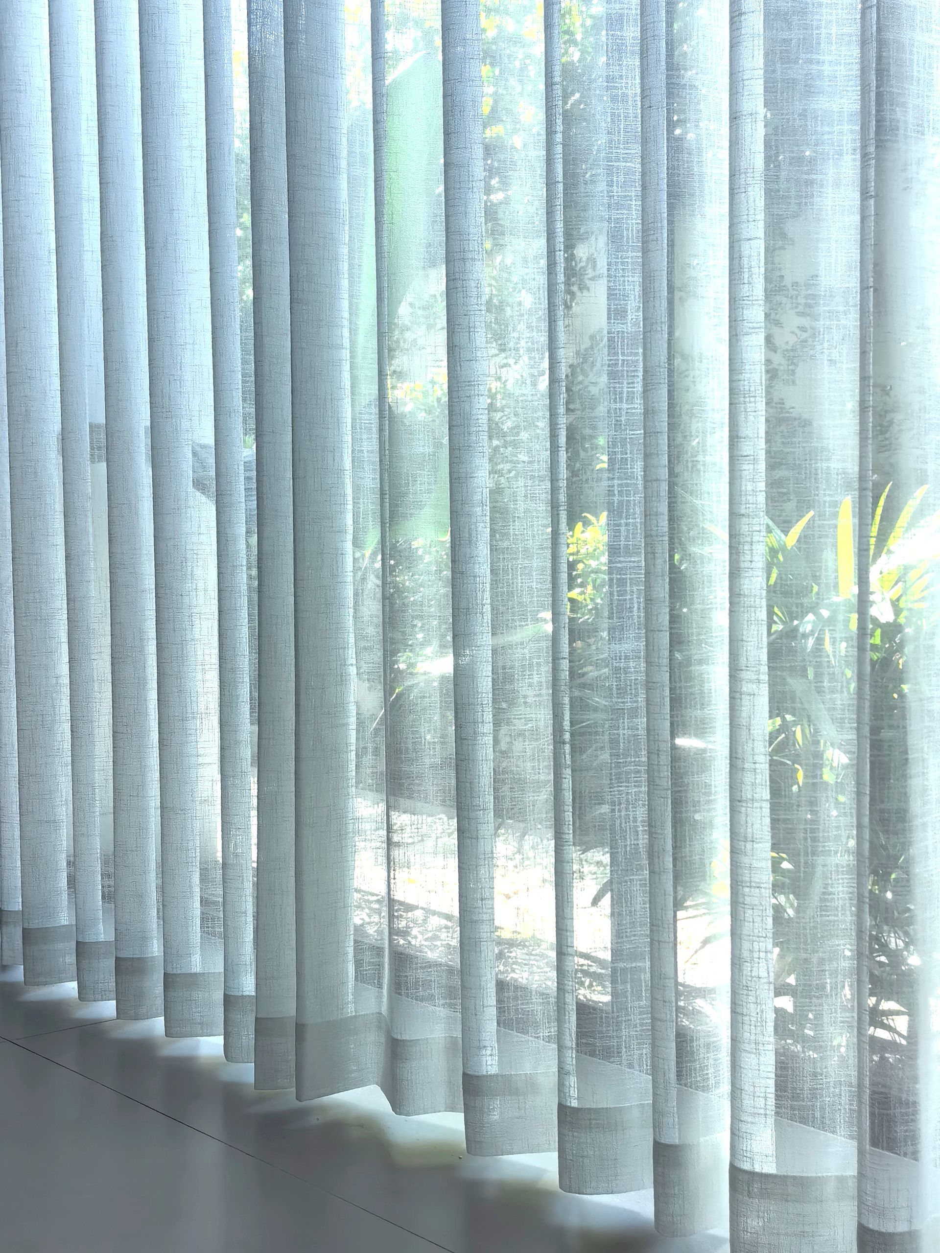 A close up of a row of vertical blinds on a window.