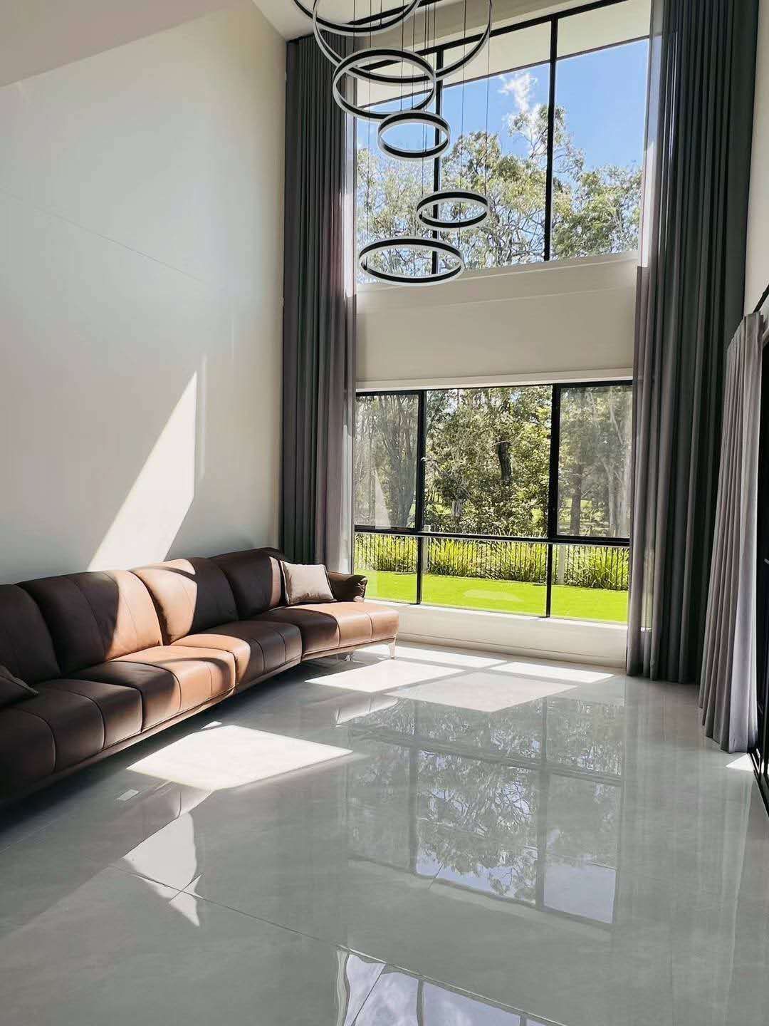A living room with a couch and a lot of windows.