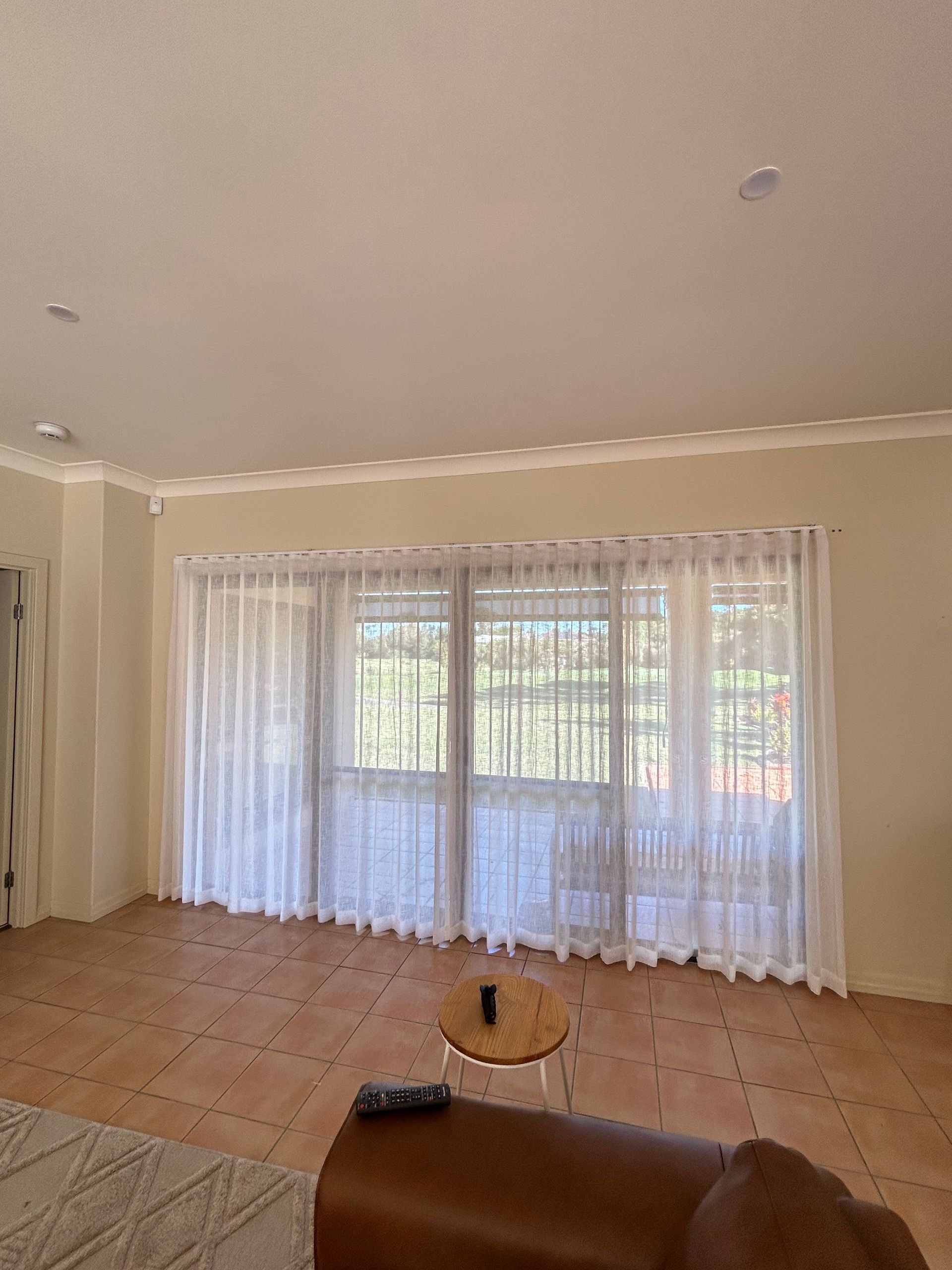 A living room with a couch , table , and curtains.