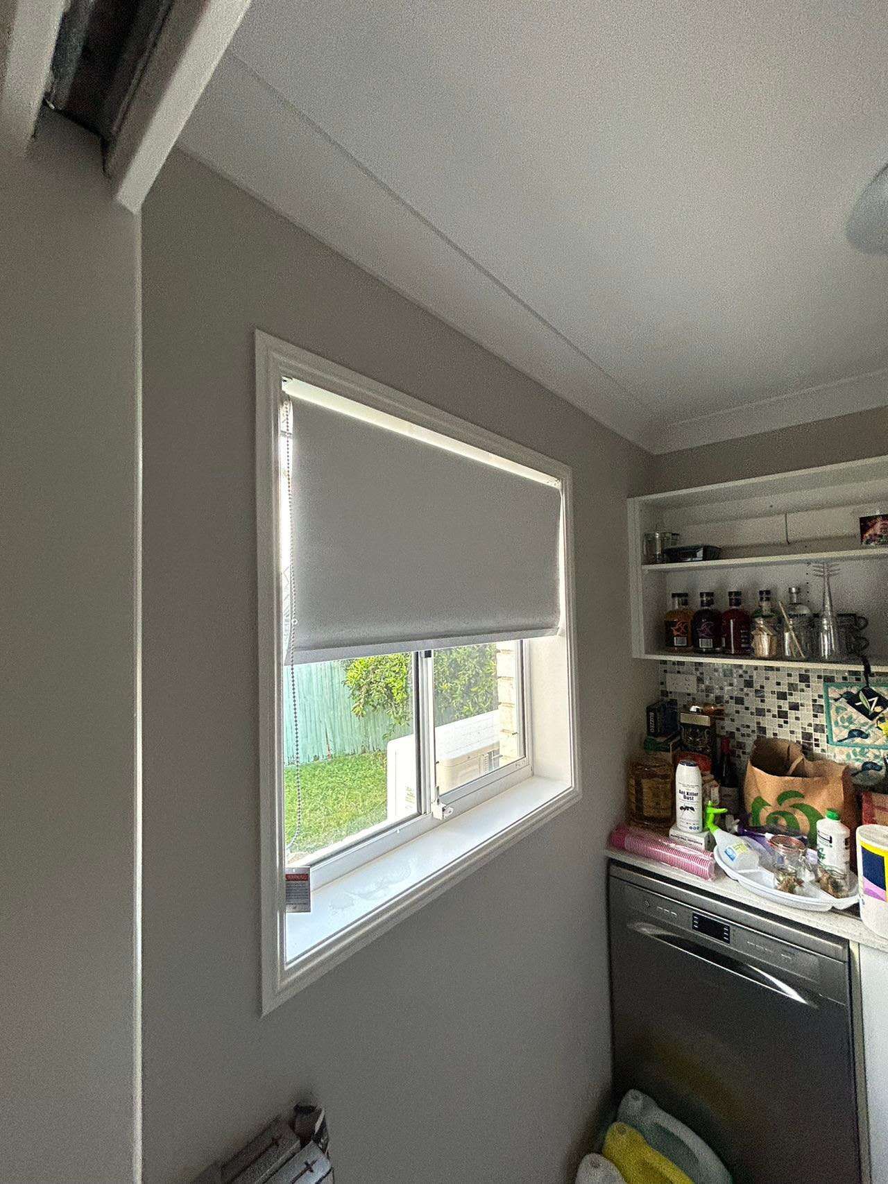 A kitchen with a large window and a dishwasher.