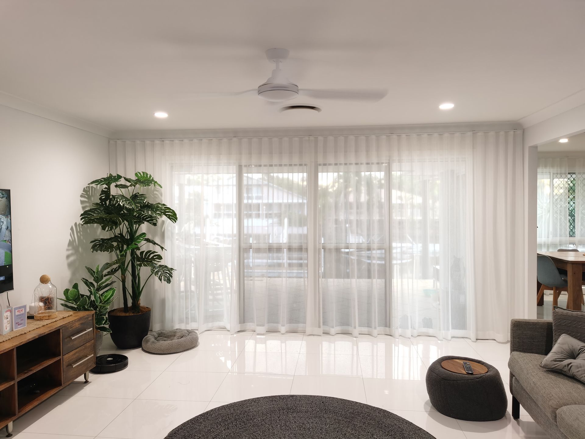 A living room with a couch , rug , ceiling fan and sliding glass doors.