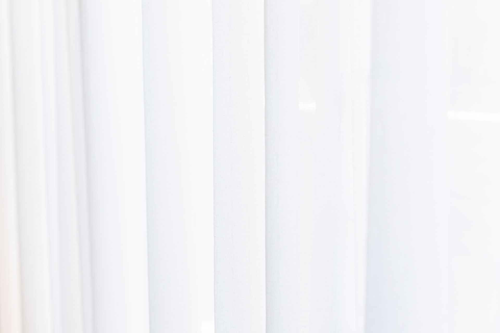 A close up of a white blind on a window.