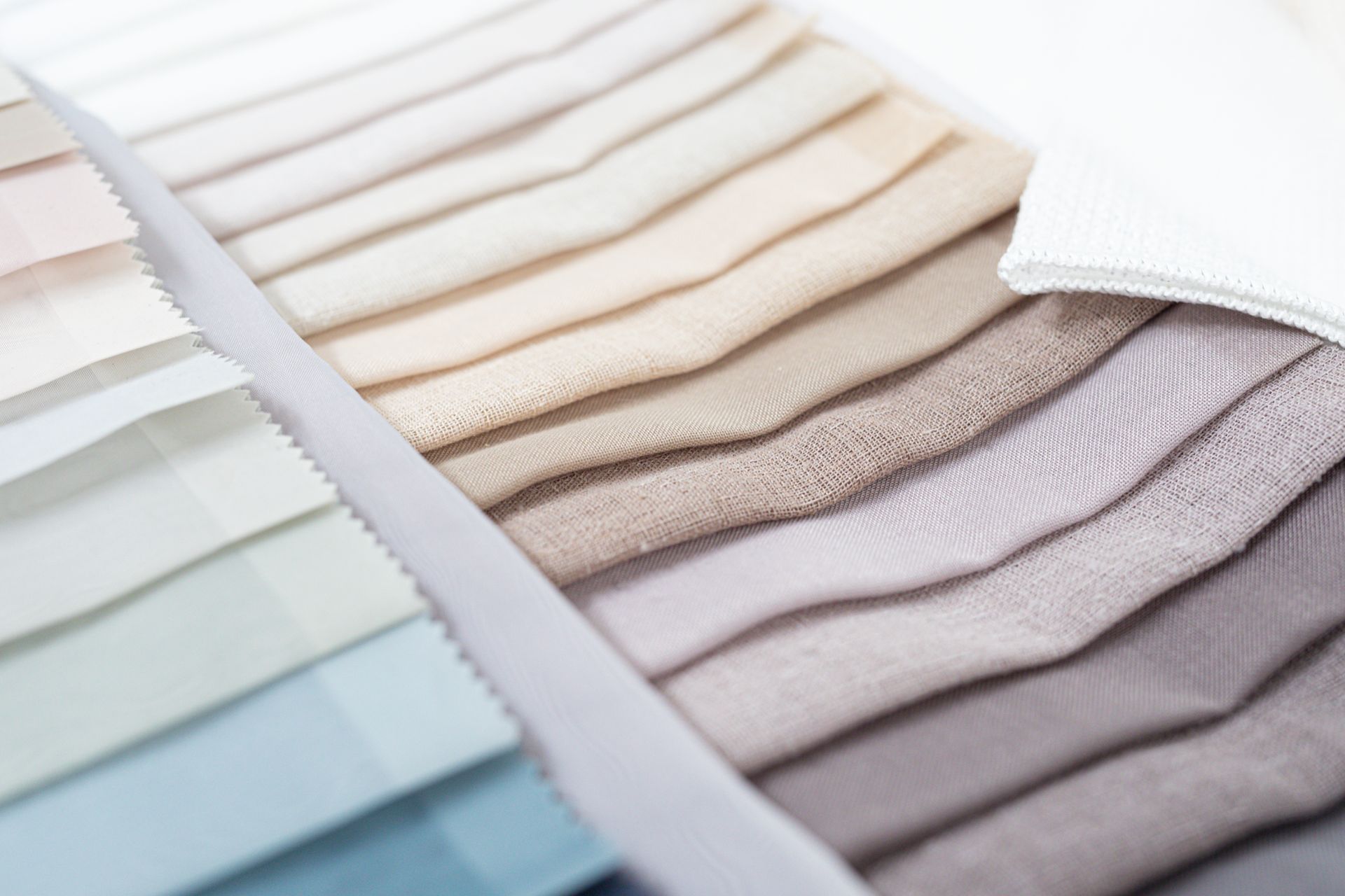 A bunch of different colored fabrics are stacked on top of each other.