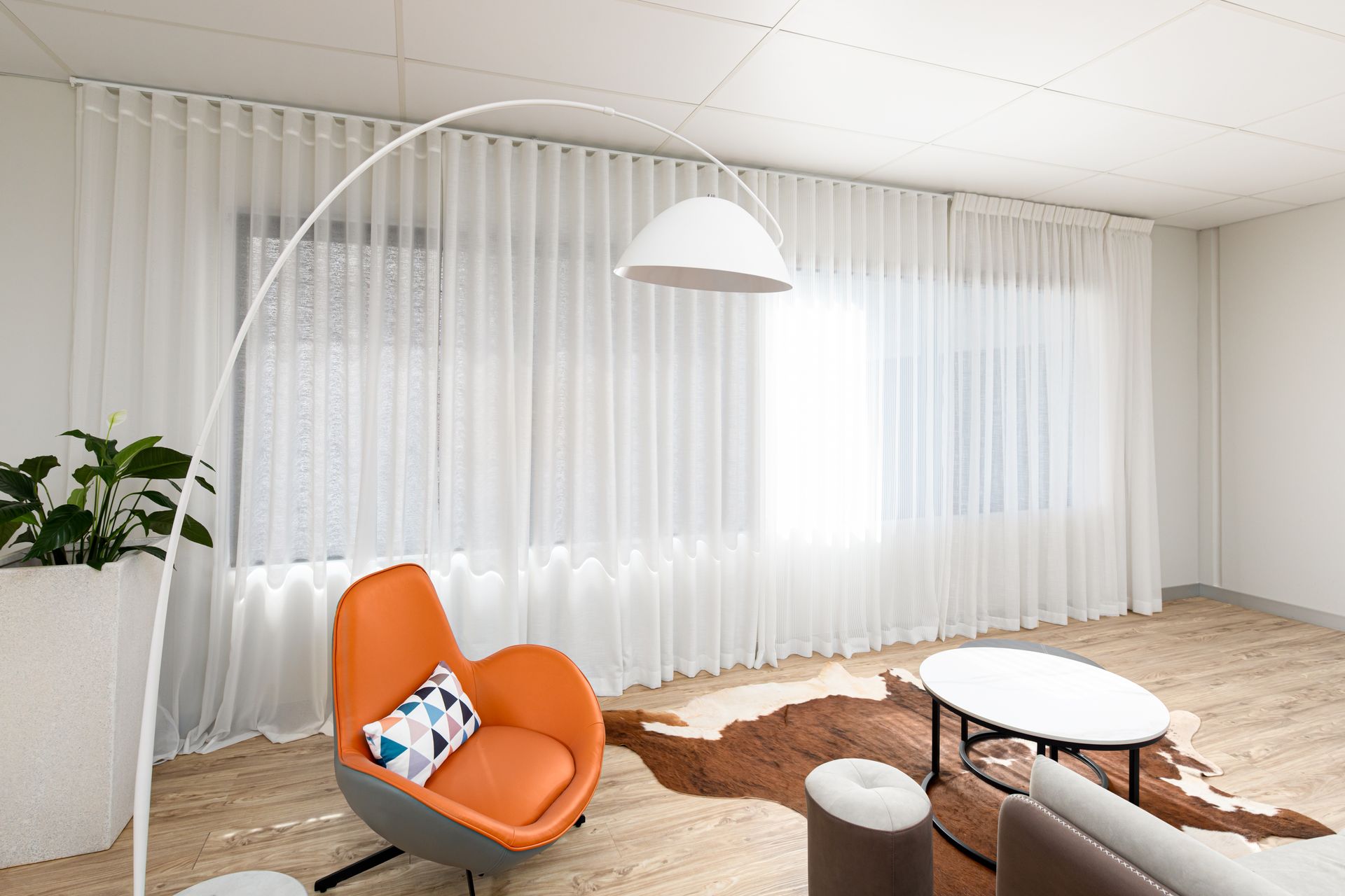 A living room with a couch , chair , table and lamp.