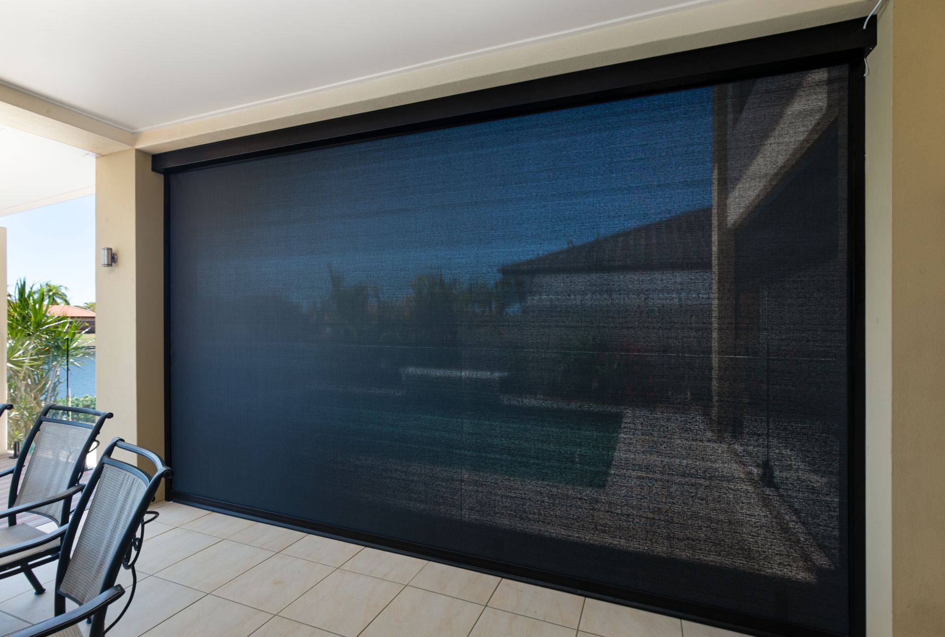 A patio with a large black screen on the wall.