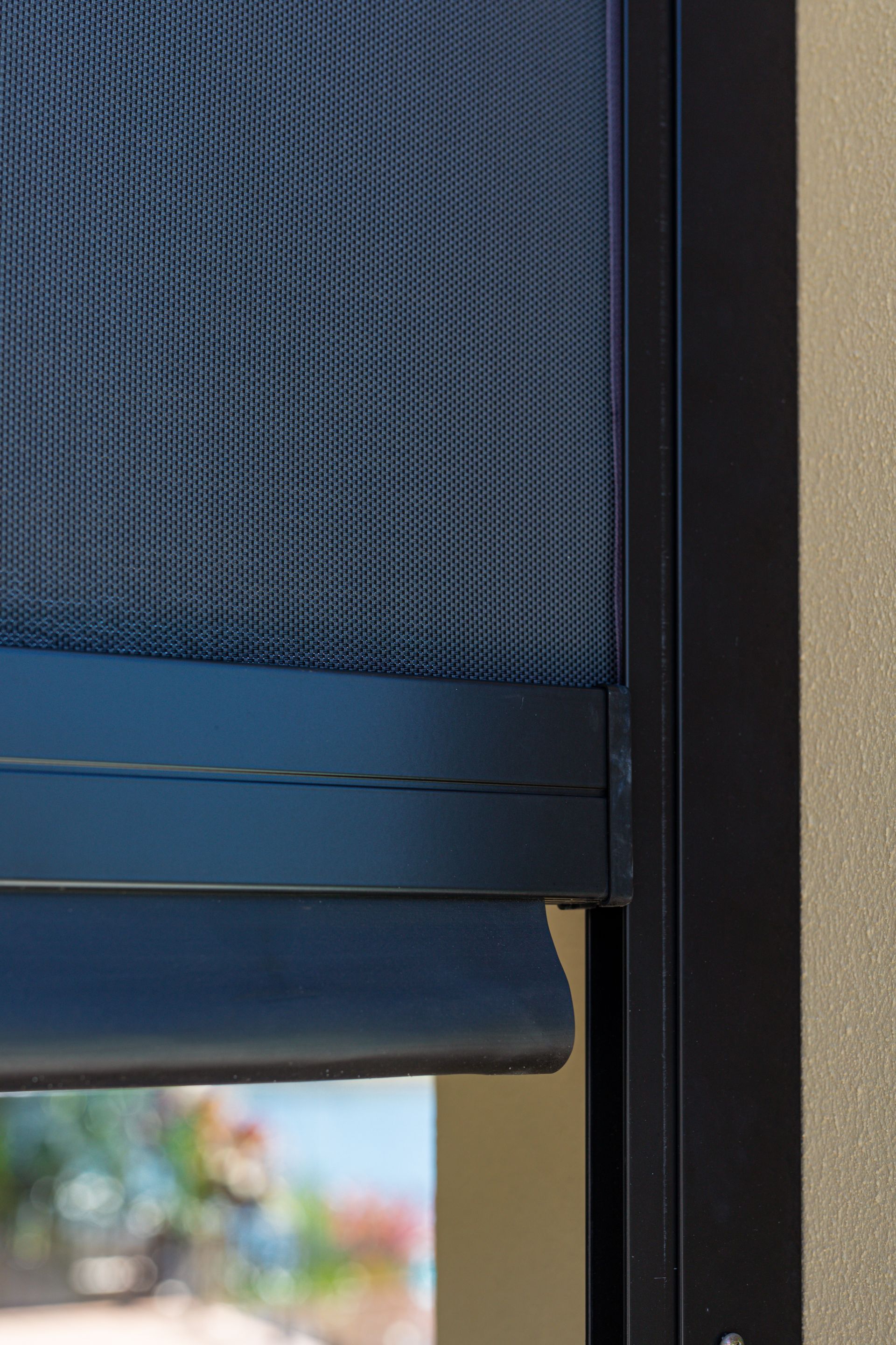 A close up of a blue blind on a window.