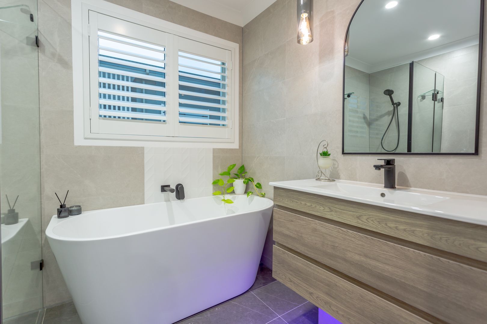 A bathroom with a bathtub , sink and mirror.