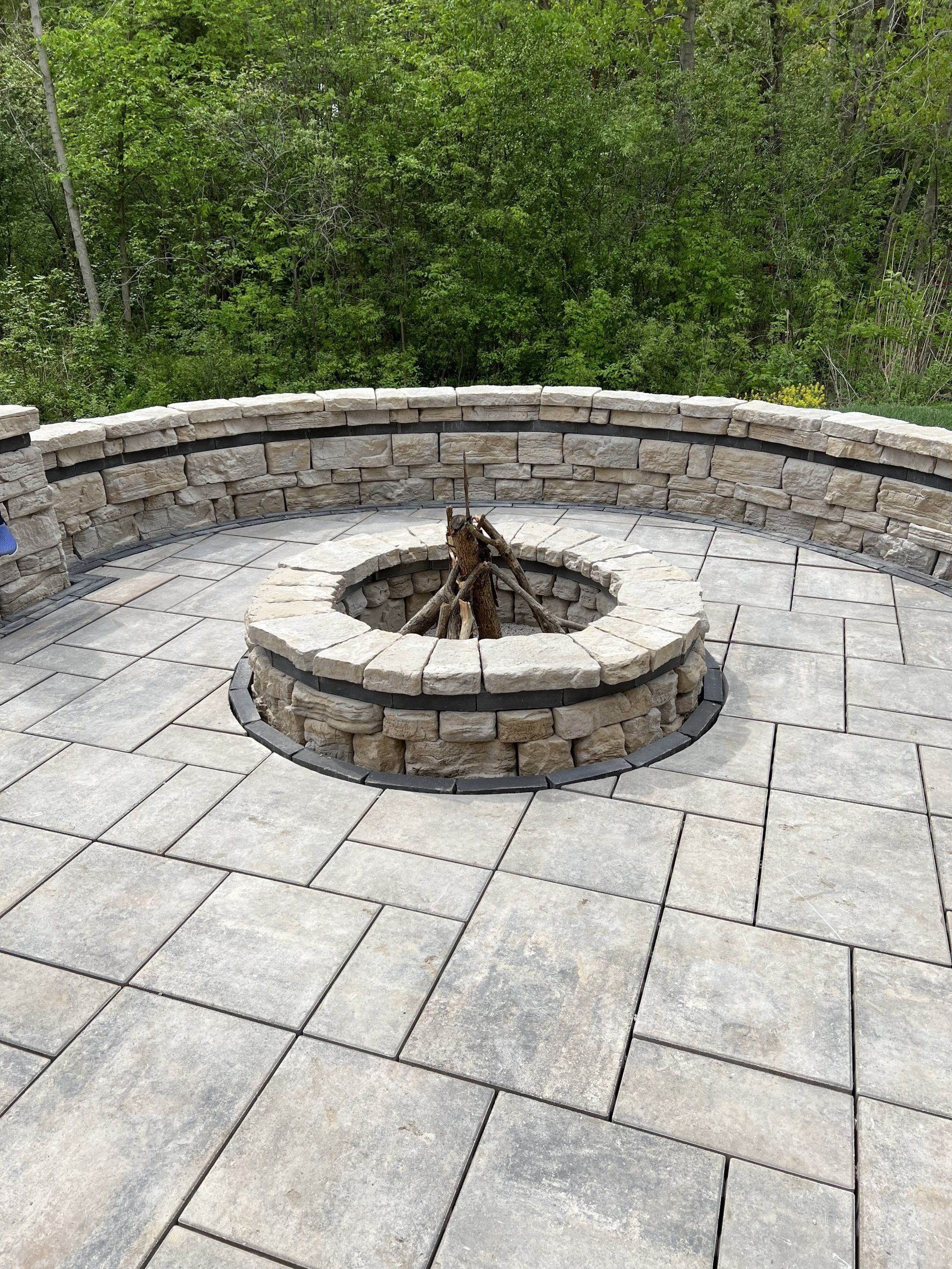 A fire pit is sitting on top of a tiled patio.