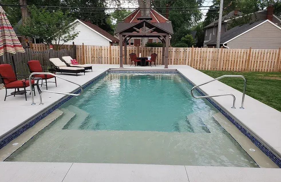 A large swimming pool with a gazebo in the backyard