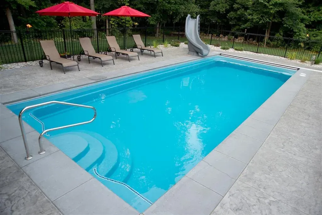 A large swimming pool with chairs and umbrellas around it