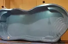 A large blue swimming pool is sitting on top of a wooden table.