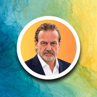 Portrait of a smiling man in a circular frame on a blue, green, and yellow watercolor background