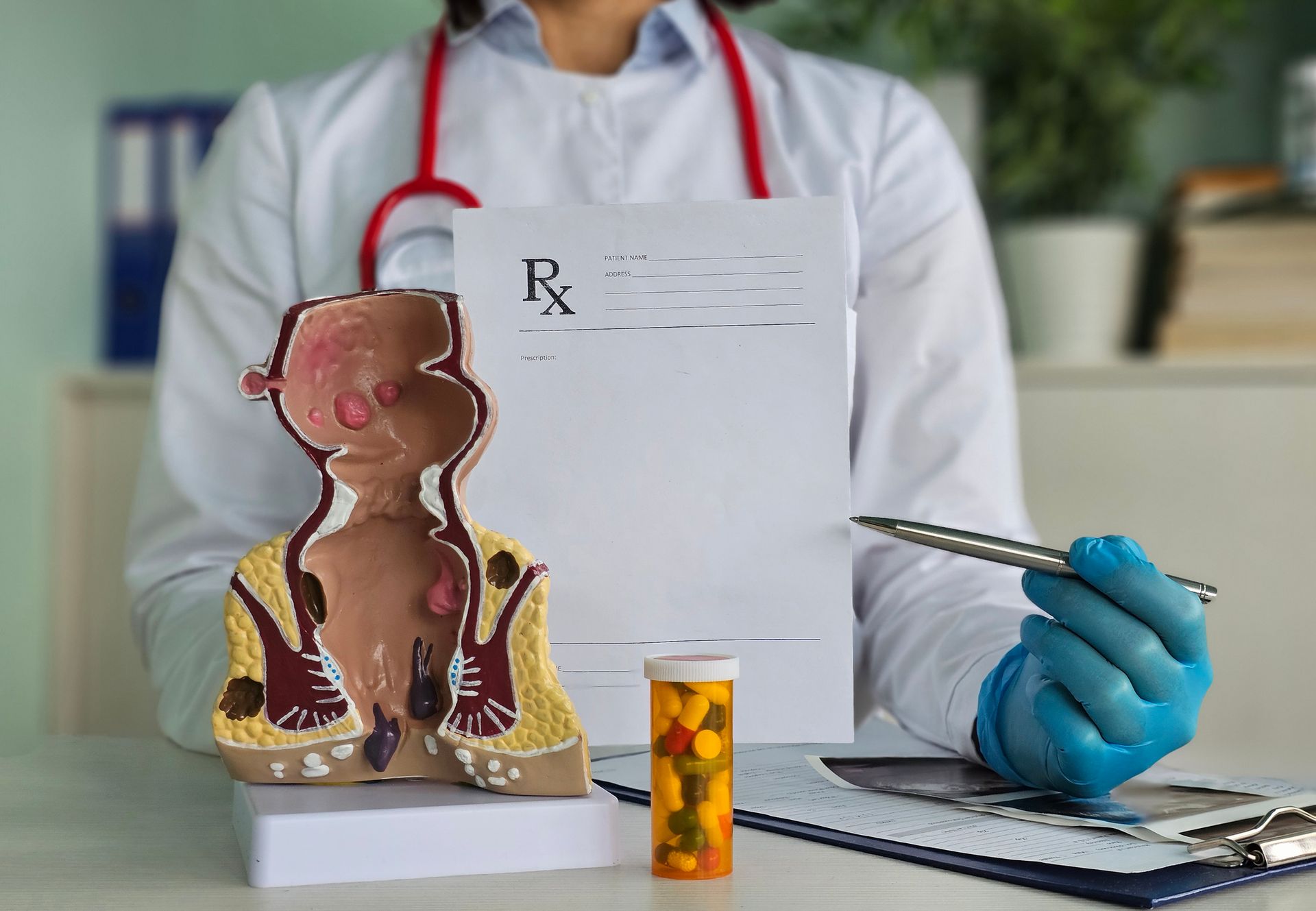 Doctor proctologist holding blisters with pills and anatomical model of rectum. Doctor proctologist holding blisters with pills and anatomical model of rectum.