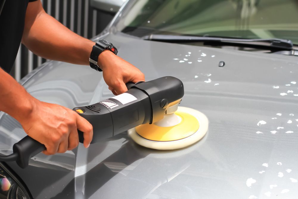 A Man is Polishing a Car With a Machine — Shane’s Car Detailing & Office Cleaning in Quirindi, NSW