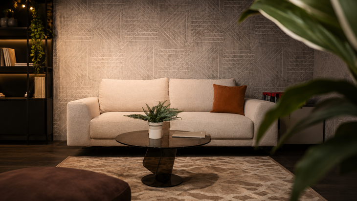 Soggiorno moderno con divano beige, cuscino arancione, tavolino rotondo e tappeto a fantasia.