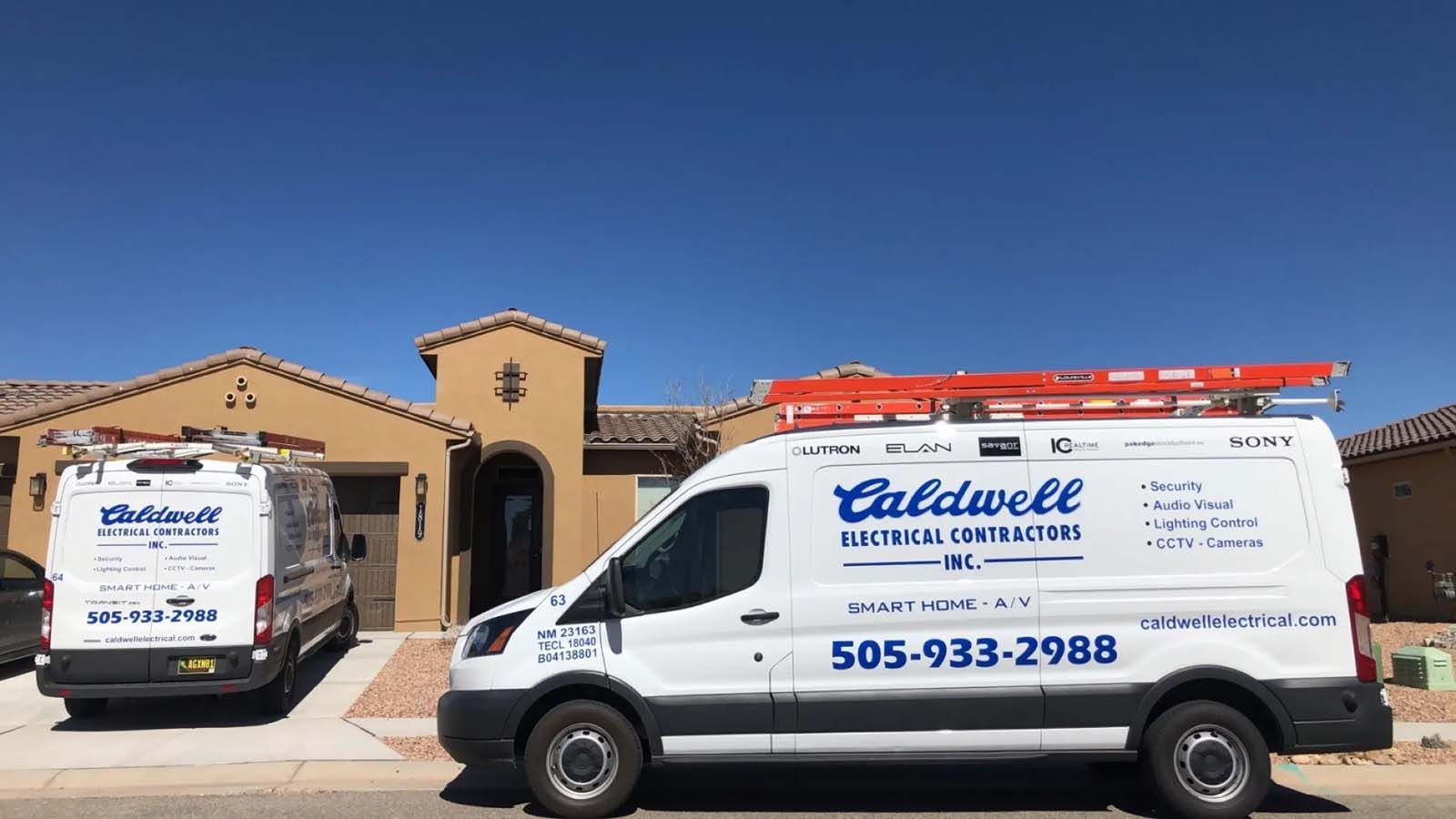 Two white vans are parked in front of a house.