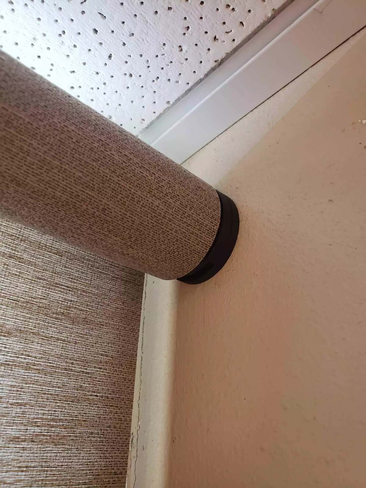 A close up of a roller blind on a wall.