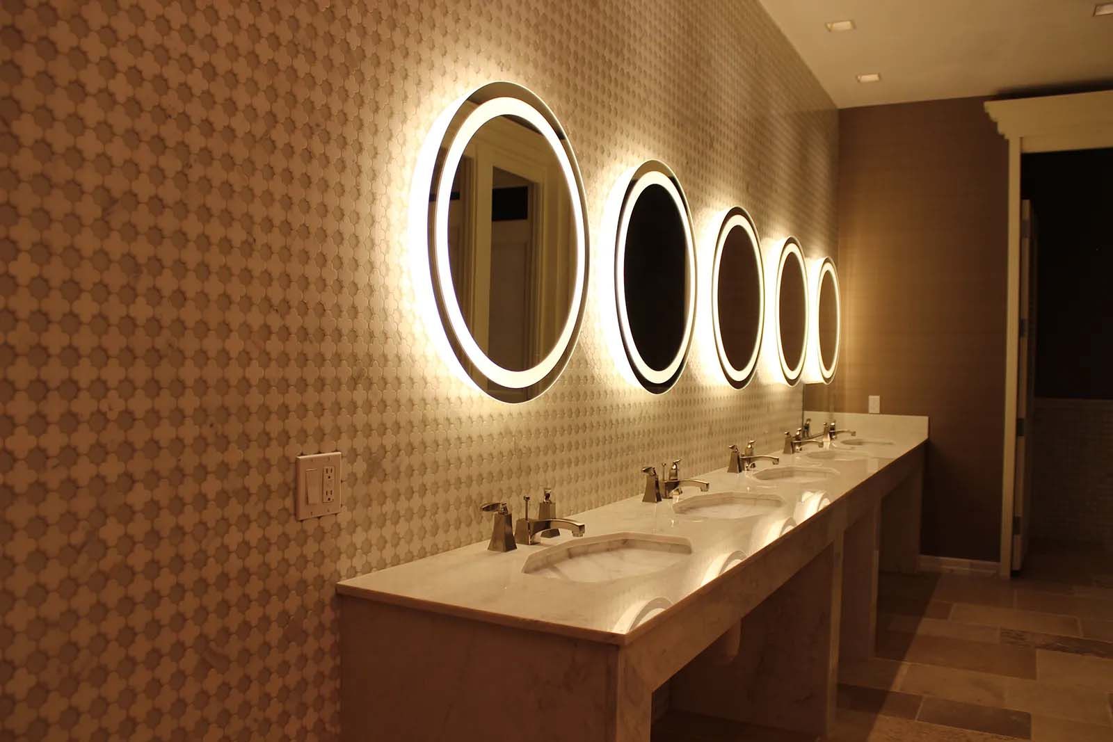 A bathroom with a row of sinks and mirrors