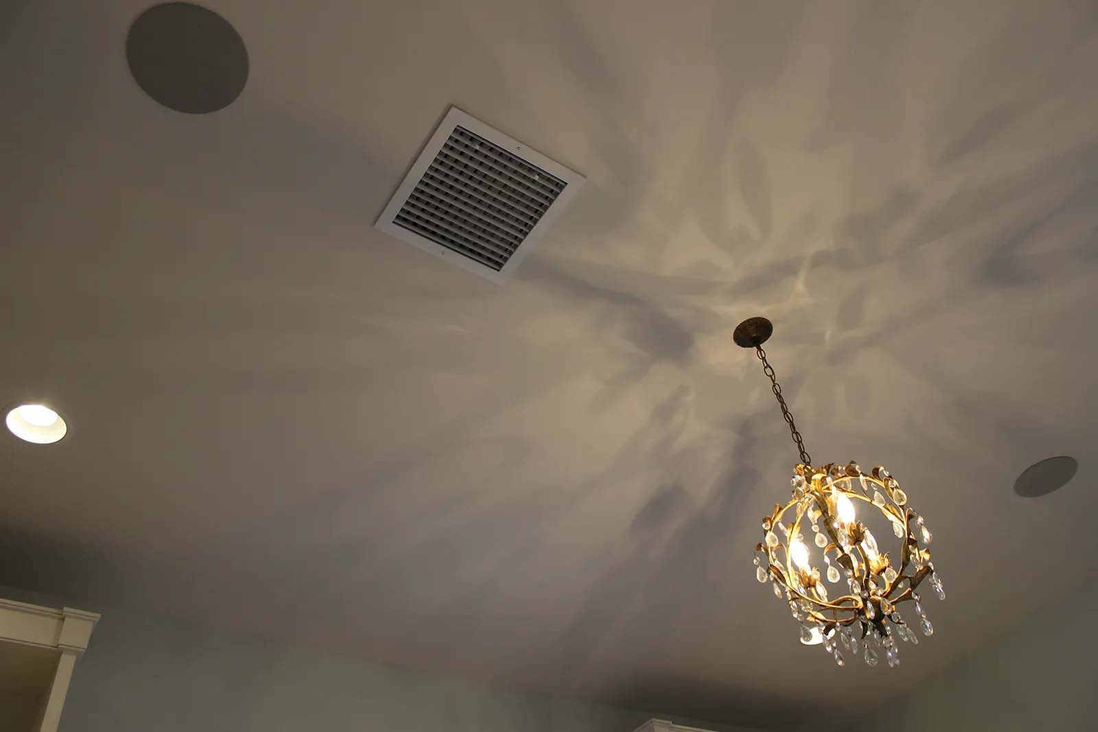A chandelier is hanging from the ceiling in a room