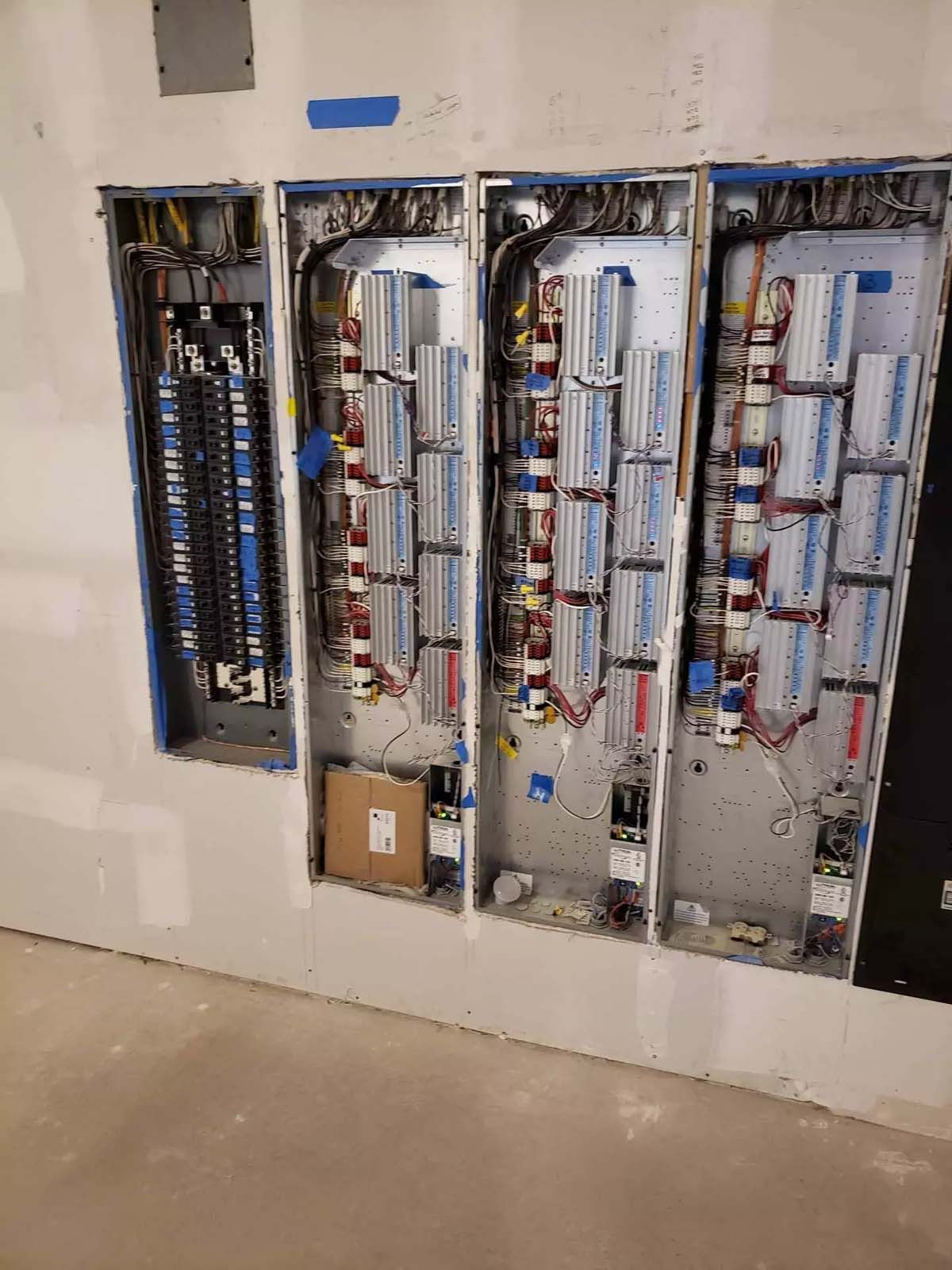 A bunch of electrical boxes are hanging on a wall.