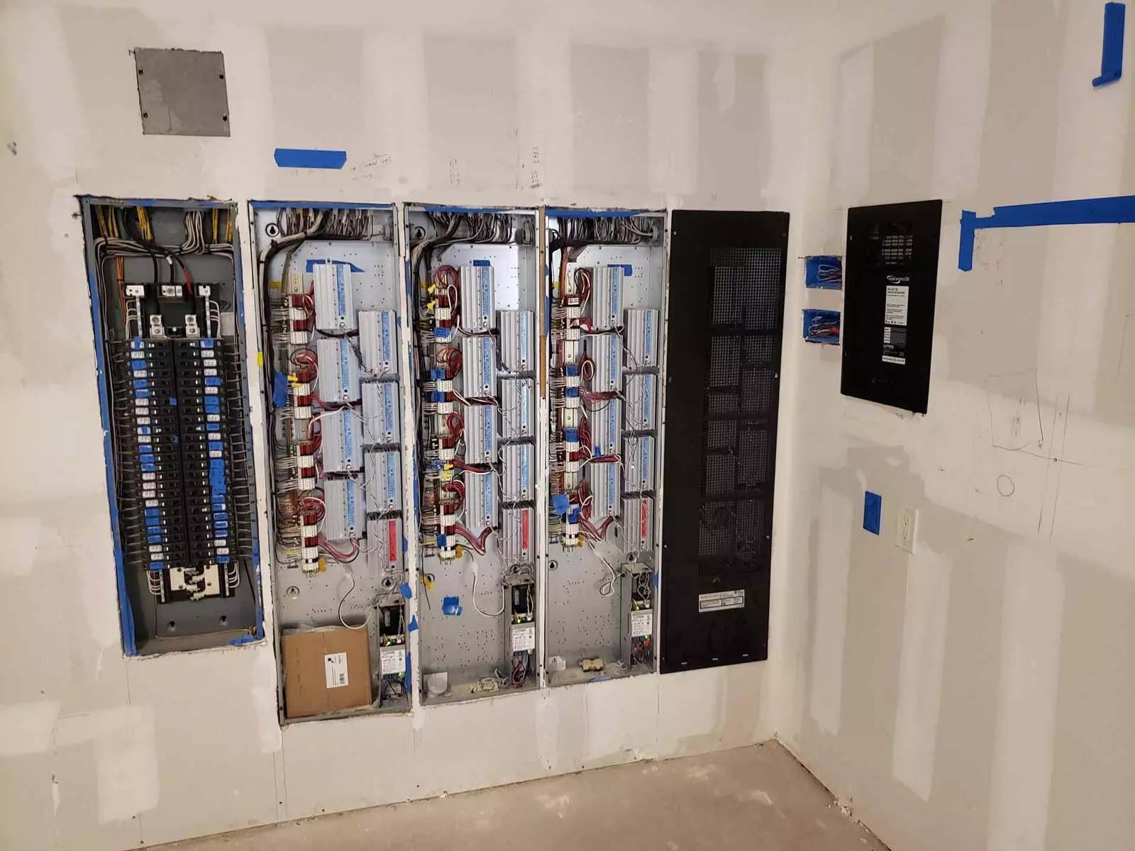A room with a lot of electrical panels on the wall.