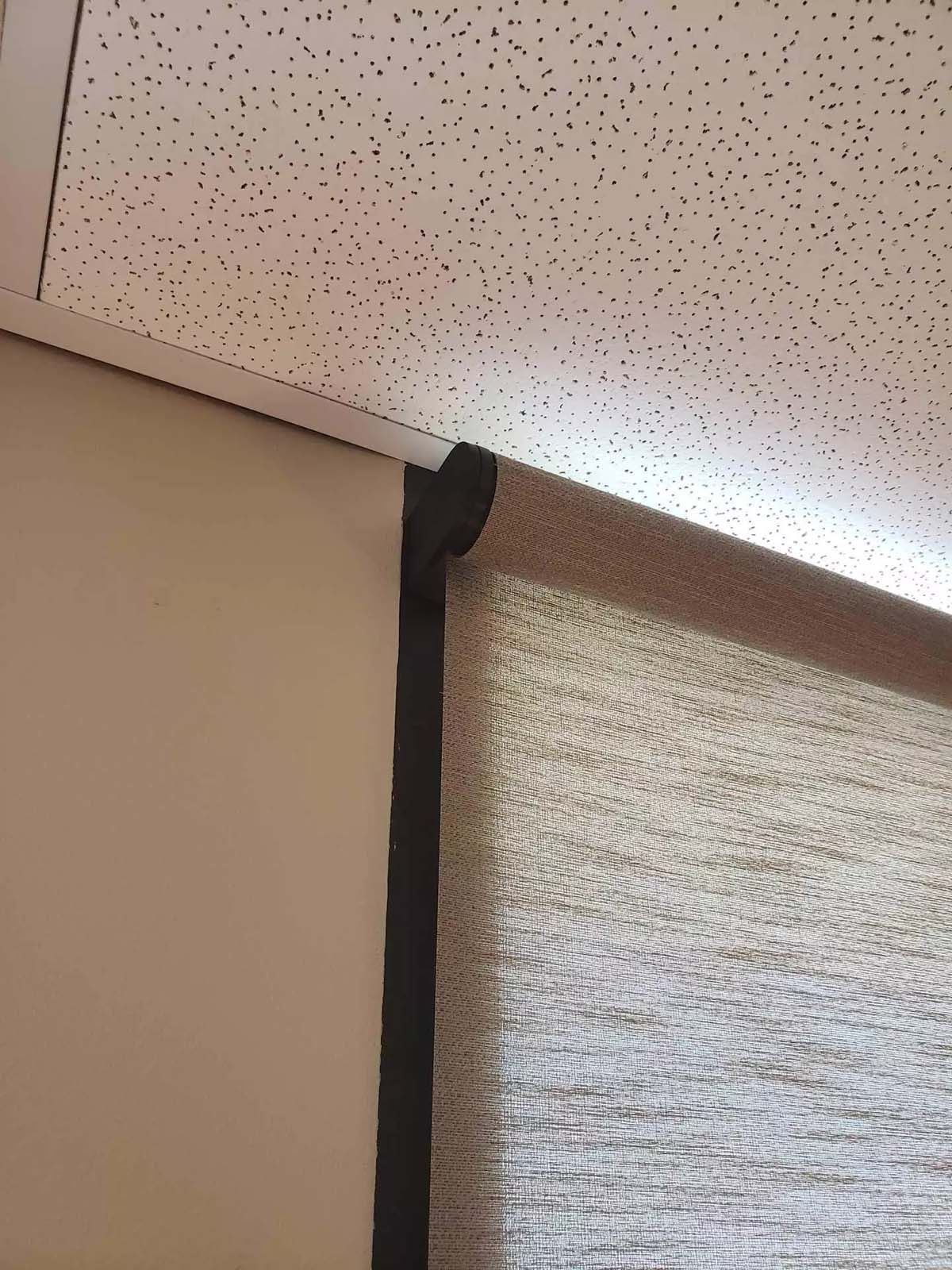 A close up of a wall with a ceiling and a window.