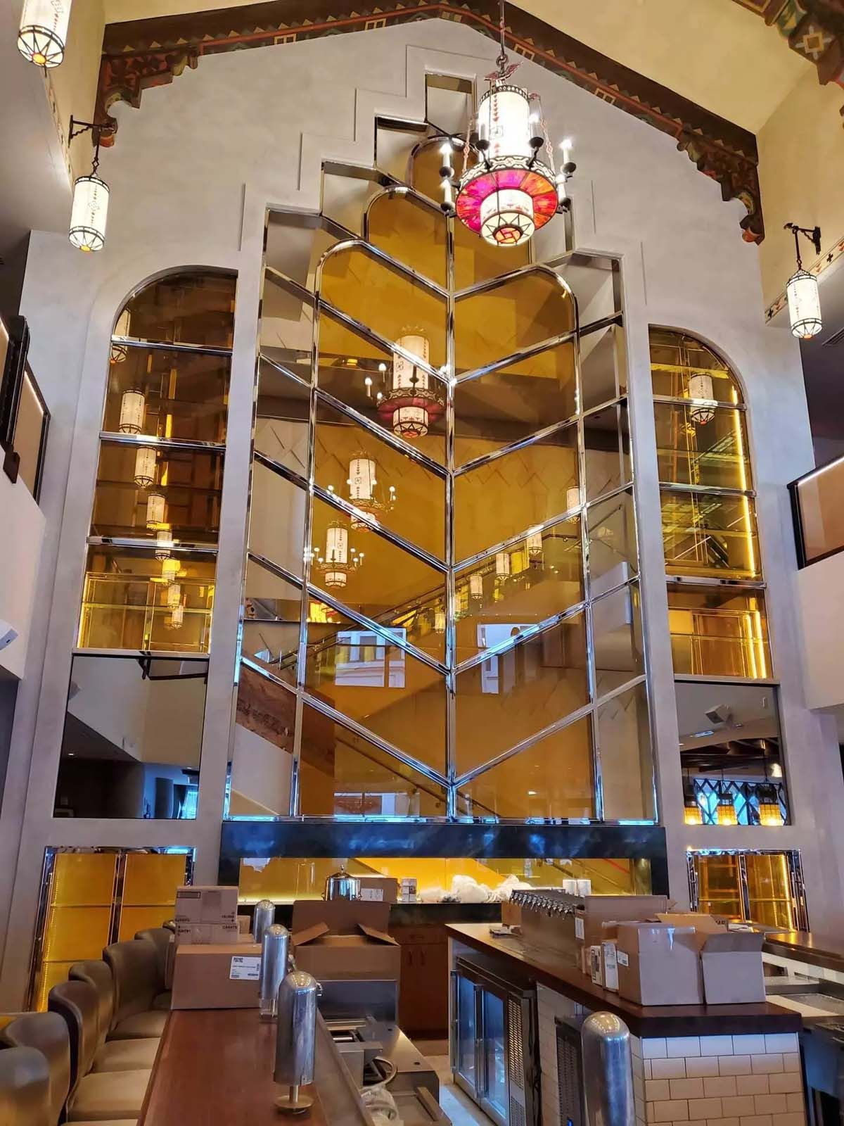 A large mirrored staircase in a building with a chandelier hanging from the ceiling