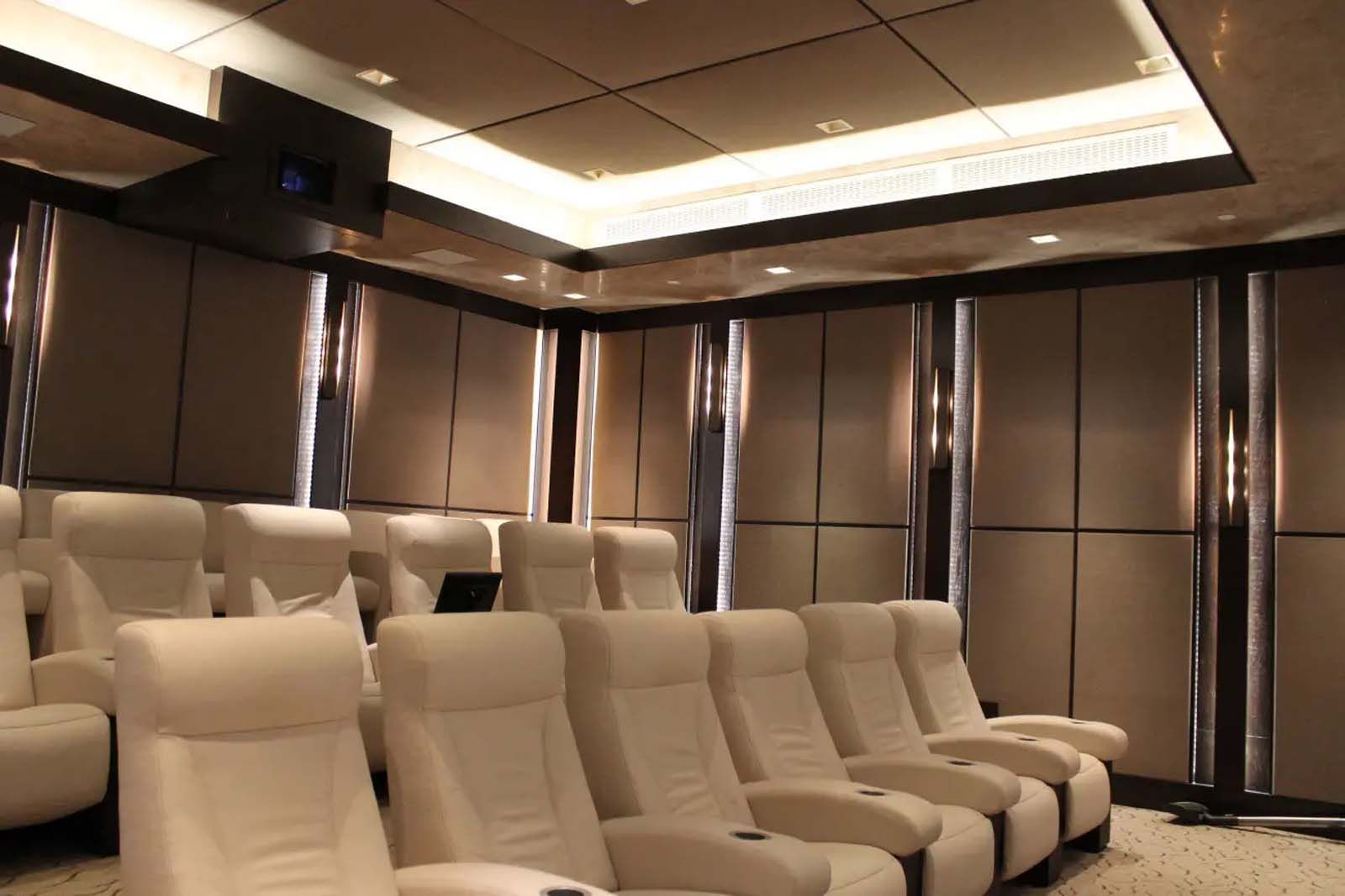 A row of white leather chairs in a theater