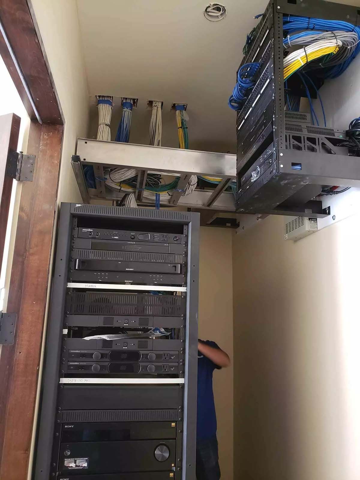 A man is working on a server rack in a room.