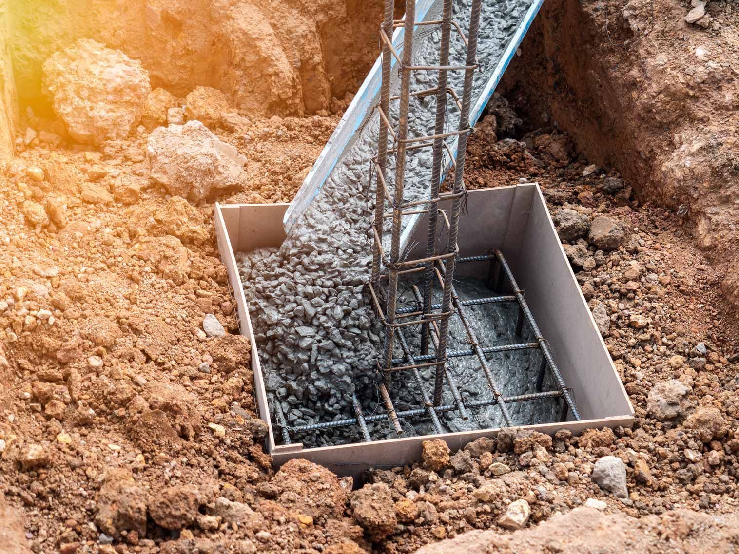 Concrete poured into a rebar foundation hole at a construction site