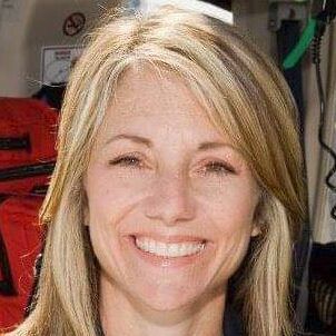 A close up of a woman smiling in an ambulance.