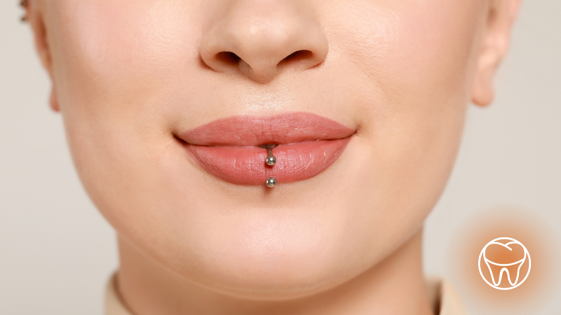 A close up of a woman 's mouth with a lip piercing.