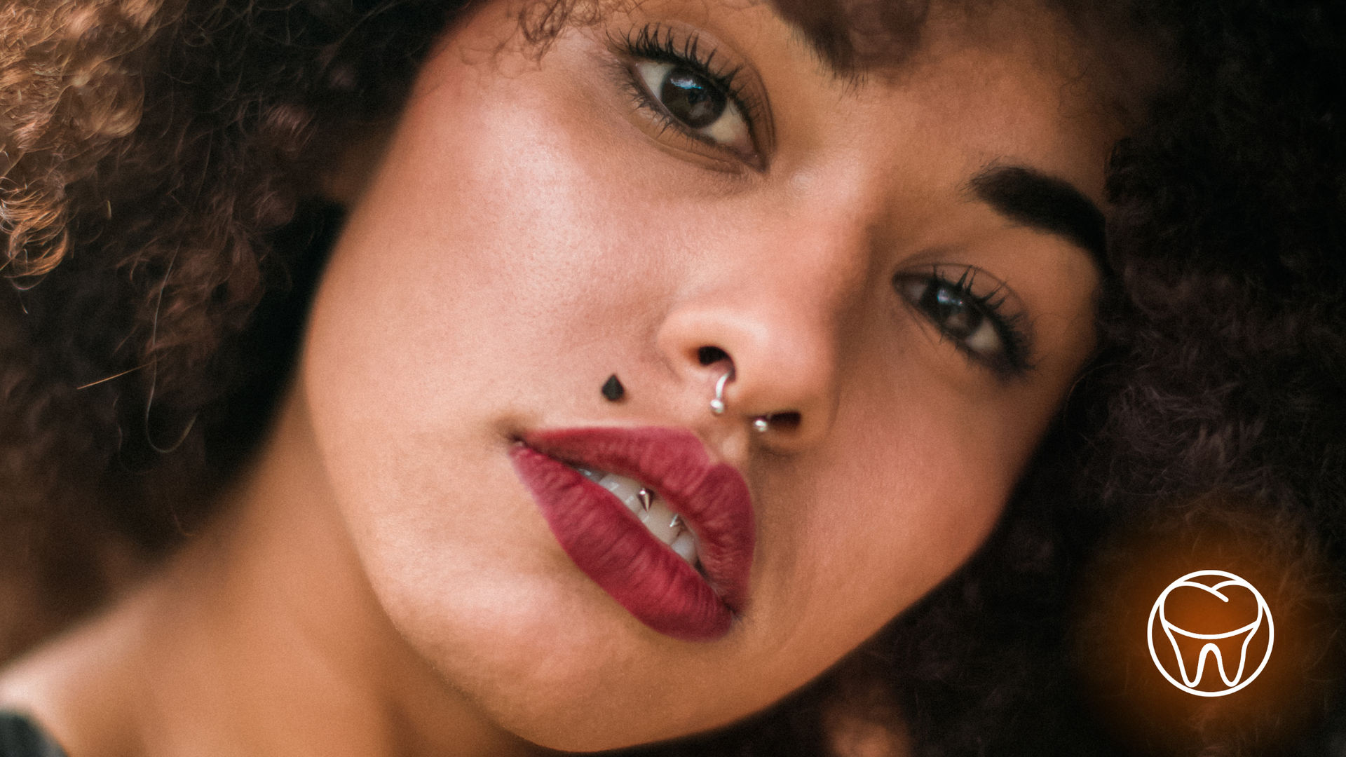 A close up of a woman 's face with a nose ring.
