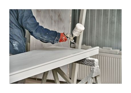 New Westminster Painting employee spraying cabinet front with white paint