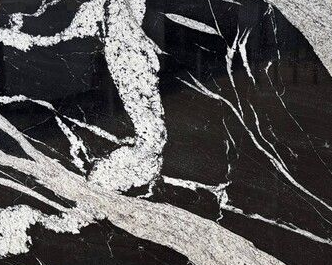 Black marble surface with bold white veining running diagonally across the stone.