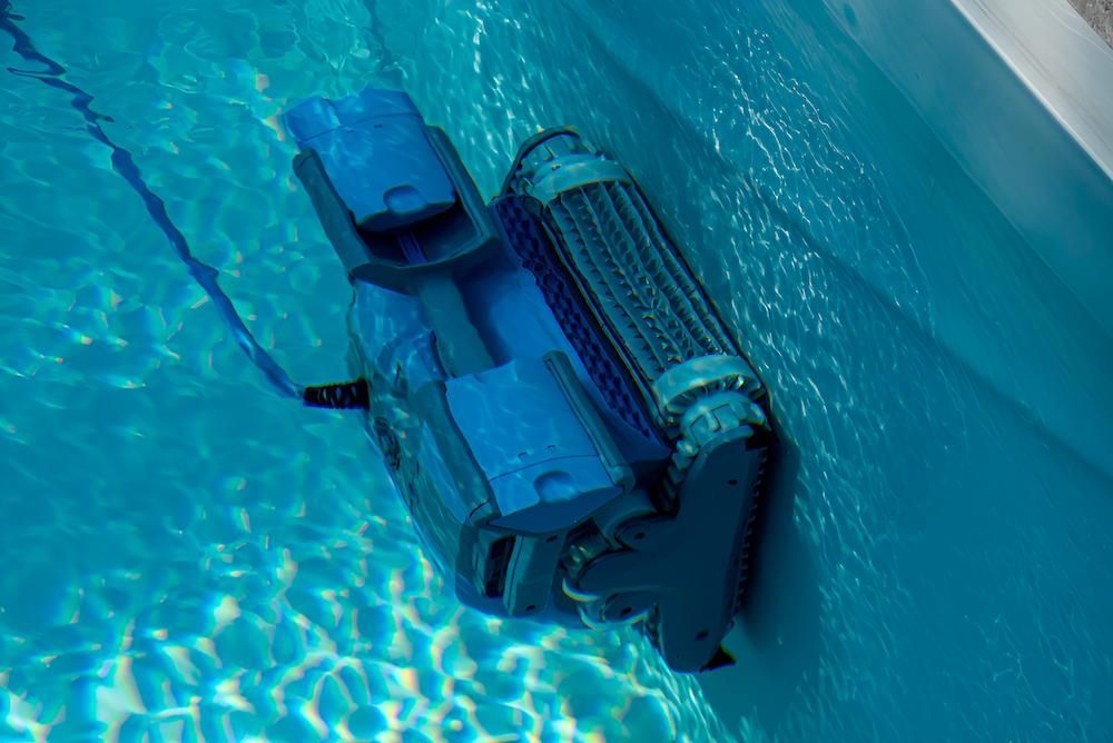 A Robotic Vacuum Cleaner is Cleaning a Swimming Pool — Sun City Pools In Hyde Park, QLD