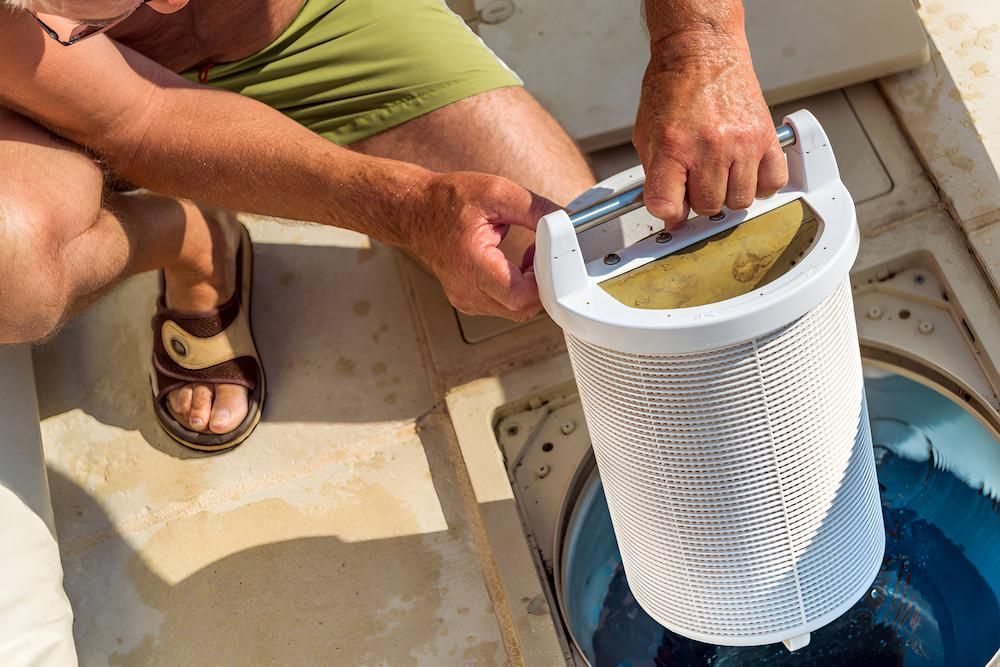 A Man is Cleaning a Pool Filter in a Swimming Pool — Sun City Pools In Hyde Park, QLD