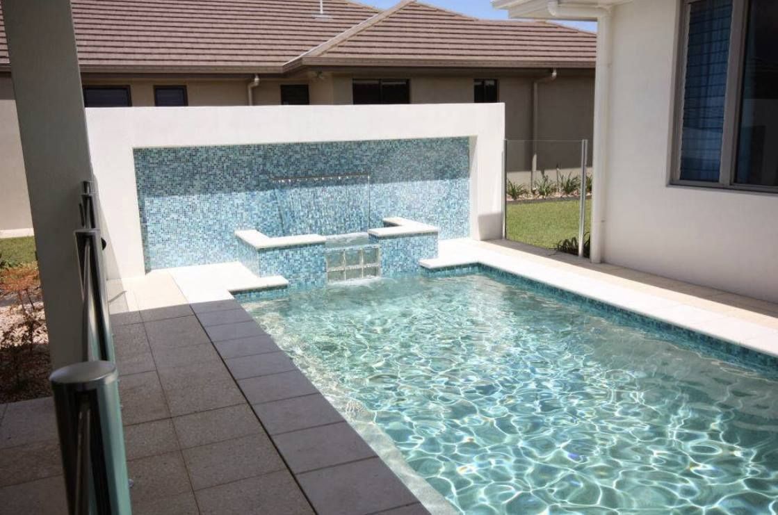 There is a Large Swimming Pool in the Backyard of a House — Sun City Pools In Hyde Park, QLD